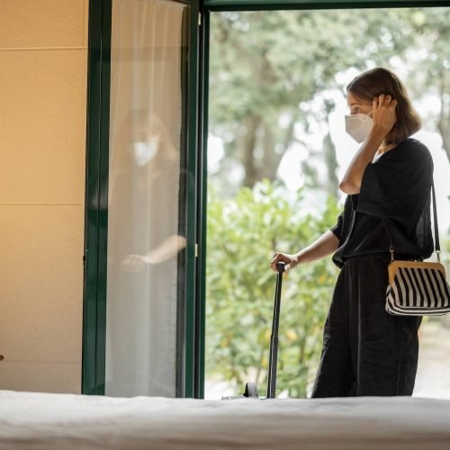 woman-in-medical-mask-entering-in-hotel-room-1.jpg